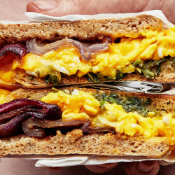 Breakfast Sandwich On An English Muffin With Charred Red Onions, Herbs, And Cheddar