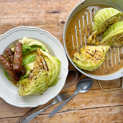 Braised Garlic And Herb Cabbage With A Pea Mash And Sausages