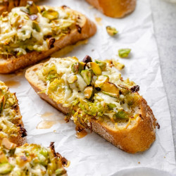 White Cheddar Brussels Sprouts &amp; Pistachio Crostini With Hot Honey