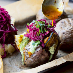 Ottolenghi Comfort: Gepofte aardappels met aubergine en groene tahin