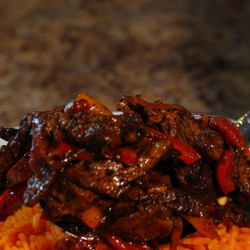 Steak fajitas over Mexican rice with queso